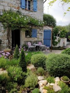 un jardin avec des portes bleues et des fleurs dans l'établissement Le Mas Saint Pierre, à Roquefort-les-Pins