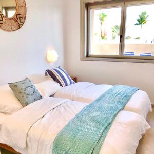 ein Schlafzimmer mit einem Bett mit Spiegel und Fenster in der Unterkunft Golf Tenerife South xx Wheel Accessible Shower xx Free WIFi xx Private Pool 30 degrees xx Two Terraces 30m2x60m2 xxFree Parking xx Mountain view xx Flatscreen 65 inch xx in San Miguel de Abona + 37 Fotos