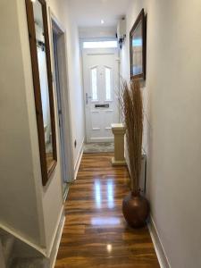 a hallway with a vase on the floor and a door at Two Bedroom End Terrace House near Birchington High Street in Birchington