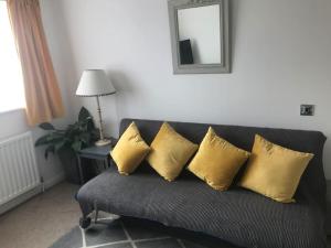 czarna kanapa z czterema żółtymi poduszkami w obiekcie Waterside Park Annex w mieście Kingsbridge