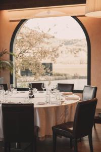 een tafel in een restaurant met een groot raam bij Hotel Vall de Bas in Joanetes