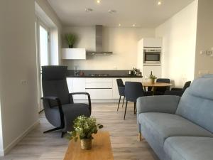 a living room with a couch and a table with chairs at Lichthuys 2.02 in Cadzand
