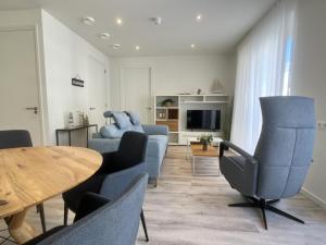 a living room with blue chairs and a table at Lichthuys 2.02 in Cadzand