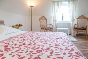 a bedroom with a bed with a red and white blanket at Vik1_23 in Westerland (Sylt)