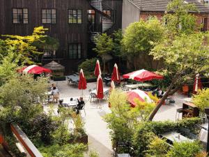 an outdoor patio with umbrellas and tables and chairs at MOB HOTEL Paris Les Puces in Saint-Ouen