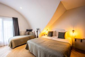 a hotel room with two beds and a window at Hotel Neptunus in Egmond aan Zee