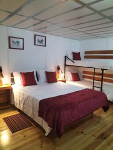 a bedroom with a bed and two bunk beds at Alojamento Raminho dos Açores in Angra do Heroísmo