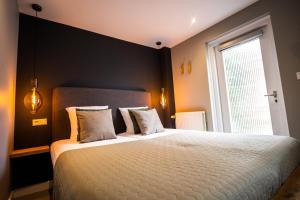 a bedroom with a large bed and a window at Hotel Neptunus in Egmond aan Zee
