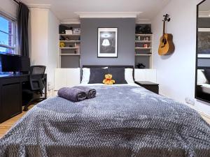 a bedroom with a bed with a teddy bear on it at Liberty Street in London