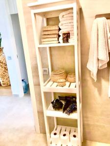 ein Bücherregal in einem Zimmer mit Handtüchern in der Unterkunft Golf Tenerife South xx Wheel Accessible Shower xx Free WIFi xx Private Pool 30 degrees xx Two Terraces 30m2x60m2 xxFree Parking xx Mountain view xx Flatscreen 65 inch xx in San Miguel de Abona