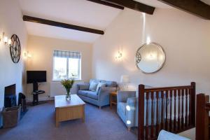 a living room with a blue couch and a tv at Norwood Cottage in Kirkby Lonsdale
