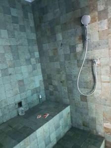a shower in a bathroom with a stone wall at Hospedaria da Barra BC in Balneário Camboriú