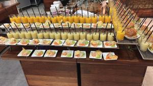 een buffet met borden en glazen sinaasappelsap bij Yarden Estate Boutique Hotel in Yesod Hamaala