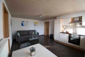 a kitchen and a living room with a couch at Ferienwohnung für 2 Personen mit direktem Zugang in Auw +2 photos