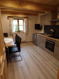 a small kitchen with a table and a table and chairs at Ferienwohnung Moharblick 2 in Großkirchheim