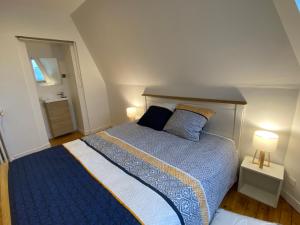 Un dormitorio con una cama con un edredón azul y blanco. en Le Loge'Mans, en Le Mans