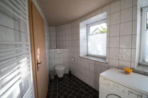 a small bathroom with a toilet and a window at Ferienwohnung für 2 Personen mit direktem Zugang in Auw