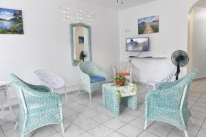 una sala de espera con sillas, mesa y espejo en Coco et Canne, en Port-Louis