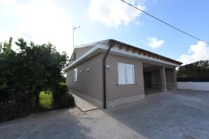 a small house with a driveway in front of it at Villa G.Giuliano in Floridia
