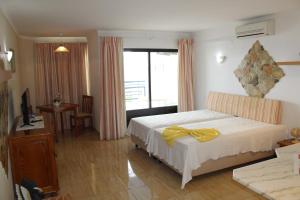 1 dormitorio con 1 cama con arco amarillo en Naturmar Praia, en Albufeira