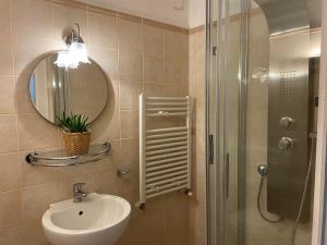 a bathroom with a sink and a shower with a mirror at Inn The Garden in Catania