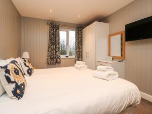 a bedroom with a large white bed with towels on it at Beech Lodge in Preston