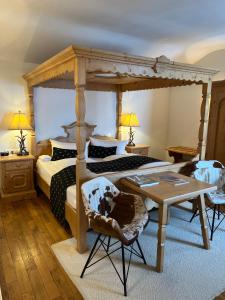 una camera con letto a baldacchino e tavolo e sedie di Seehotel Luitpold a Tegernsee