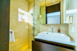 a bathroom with a sink and a glass shower at Mountain Side Hakuba in Hakuba