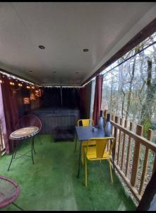 eine Terrasse mit einem Tisch und Stühlen auf dem Balkon in der Unterkunft L'Ange De Fer in Illoud