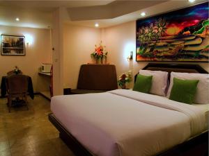 Habitación de hotel con cama grande y escritorio. en Paradise Inn, en Karon Beach