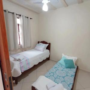 a small room with two beds and a window at LAGOA II SAQUAREMA RJ in Saquarema