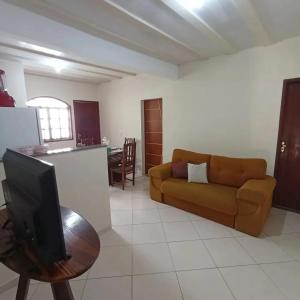 uma sala de estar com um sofá e uma mesa com uma televisão em LAGOA II SAQUAREMA RJ em Saquarema