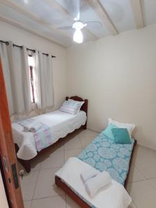 a bedroom with two beds and a ceiling fan at LAGOA II SAQUAREMA RJ in Saquarema