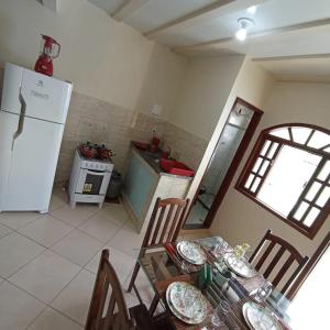 a kitchen with a table and chairs and a refrigerator at LAGOA II SAQUAREMA RJ in Saquarema