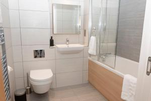 ein Badezimmer mit einem WC, einem Waschbecken und einer Badewanne in der Unterkunft Modern Brixton Apartment in London