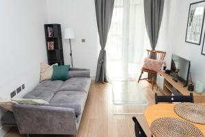 a living room with a couch and a table at Modern Brixton Apartment in London