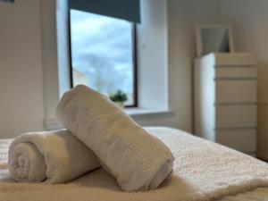 - Toalla sobre una cama con ventana en Beach House in Berwick Upon Tweed - 2 Double Bedrooms, en Spittal
