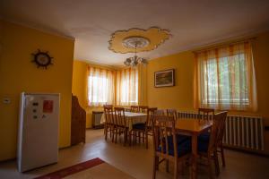 a kitchen and dining room with a table and chairs at Galéria Vendégház in Mezőkövesd