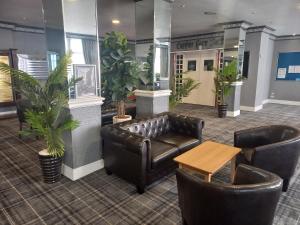 a waiting room with leather furniture and plants at Norbreck Castle Hotel Blackpool in Blackpool