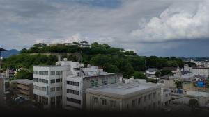 um edifício no topo de uma colina numa cidade em Tsuyama Central Hotel Annex em Tuyama