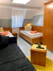 ein Hotelzimmer mit 2 Betten und einem Sofa in der Unterkunft M-Hotel in Stuttgart
