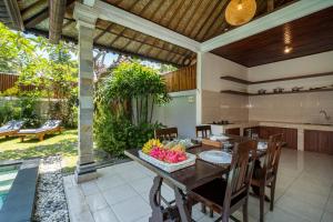 水明漾‎的住宿－Villa Kori Bali Kubu, 9 people maximum, close to Seminyak Beach，室外厨房以及带桌椅的用餐室。