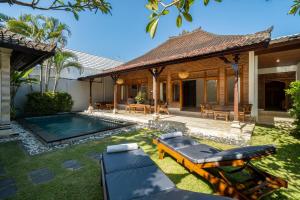 水明漾‎的住宿－Villa Kori Bali Kubu, 9 people maximum, close to Seminyak Beach，一个带游泳池和房子的后院