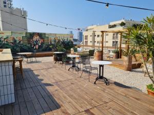 a patio with tables and chairs on a roof at Rena's House in Tel Aviv