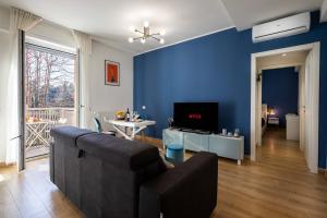 - un salon avec un canapé et un mur bleu dans l'établissement Affori House, à Milan