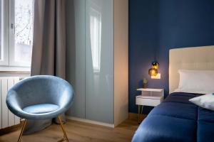 Un dormitorio con una silla azul junto a una cama en Affori House, en Milán