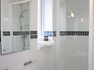 a bathroom with a shower and a sink and a mirror at Pass the Keys Pendine hot tub sea views in Carmarthen
