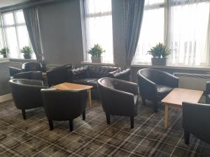 a waiting room with chairs and tables and windows at Norbreck Castle Hotel Blackpool in Blackpool +32 photos