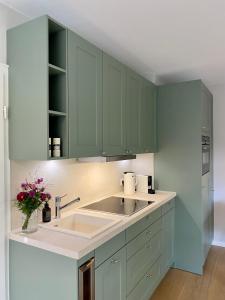 a kitchen with green cabinets and a sink at Süderhygge in Keitum