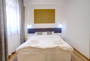 a bedroom with a large bed with two pillows at Pensiunea & SPA Boema Ploiesti in Ploieşti